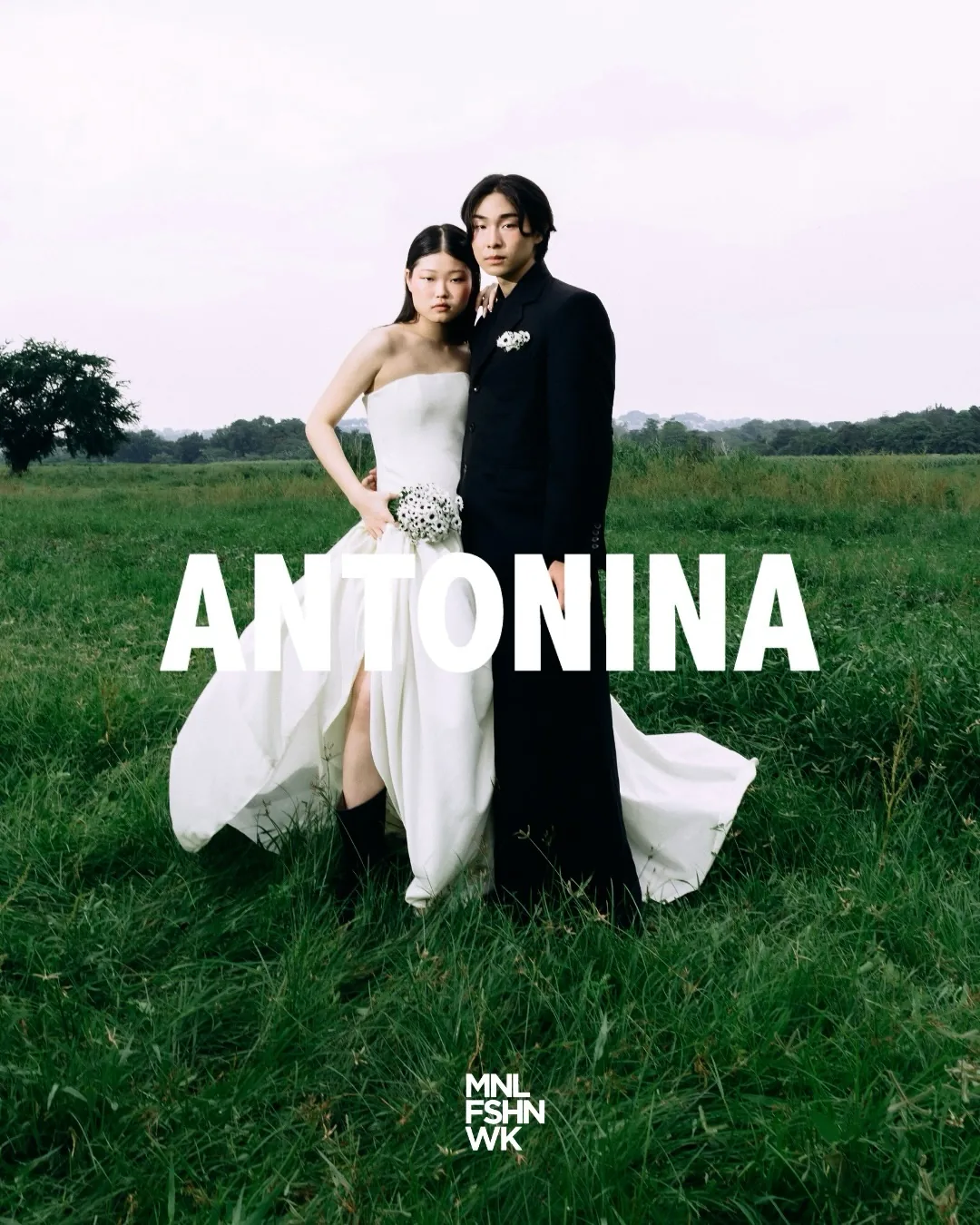 Antonina bridal-inspired campaign: a strapless ivory gown with a raw-hem train paired with a tailored black suit, shot in an open field